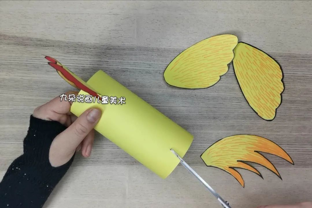 步骤4：将直筒两边同一面各自剪一刀，分别将鸡头和尾巴插进去。翅膀用双面胶粘在直筒的两侧。