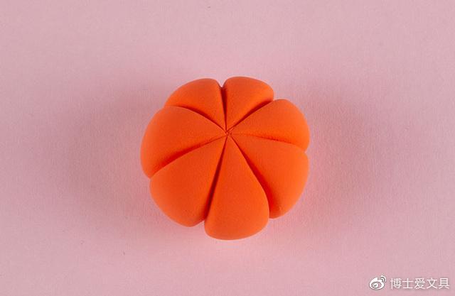 步骤3：接下来我们做个小南瓜，桔红色粘土做出南瓜的形状，并用工具压出南瓜上面的纹路。