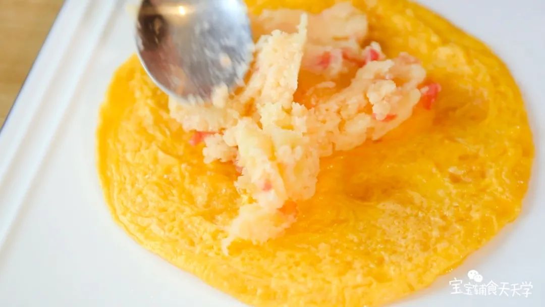 在蛋皮上铺上土豆泥，抹平表面