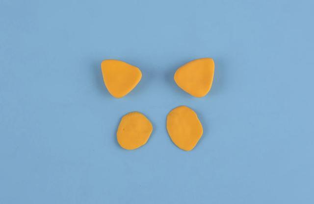 步骤2：用橙色粘土做出上图的形状，两只耳朵，两片做脸部的装饰。