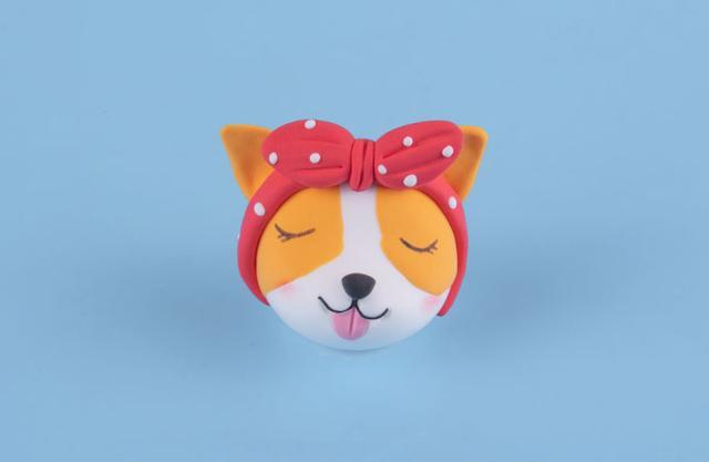 步骤7：把蝴蝶结发卡组装好然后戴到柯基的头上。