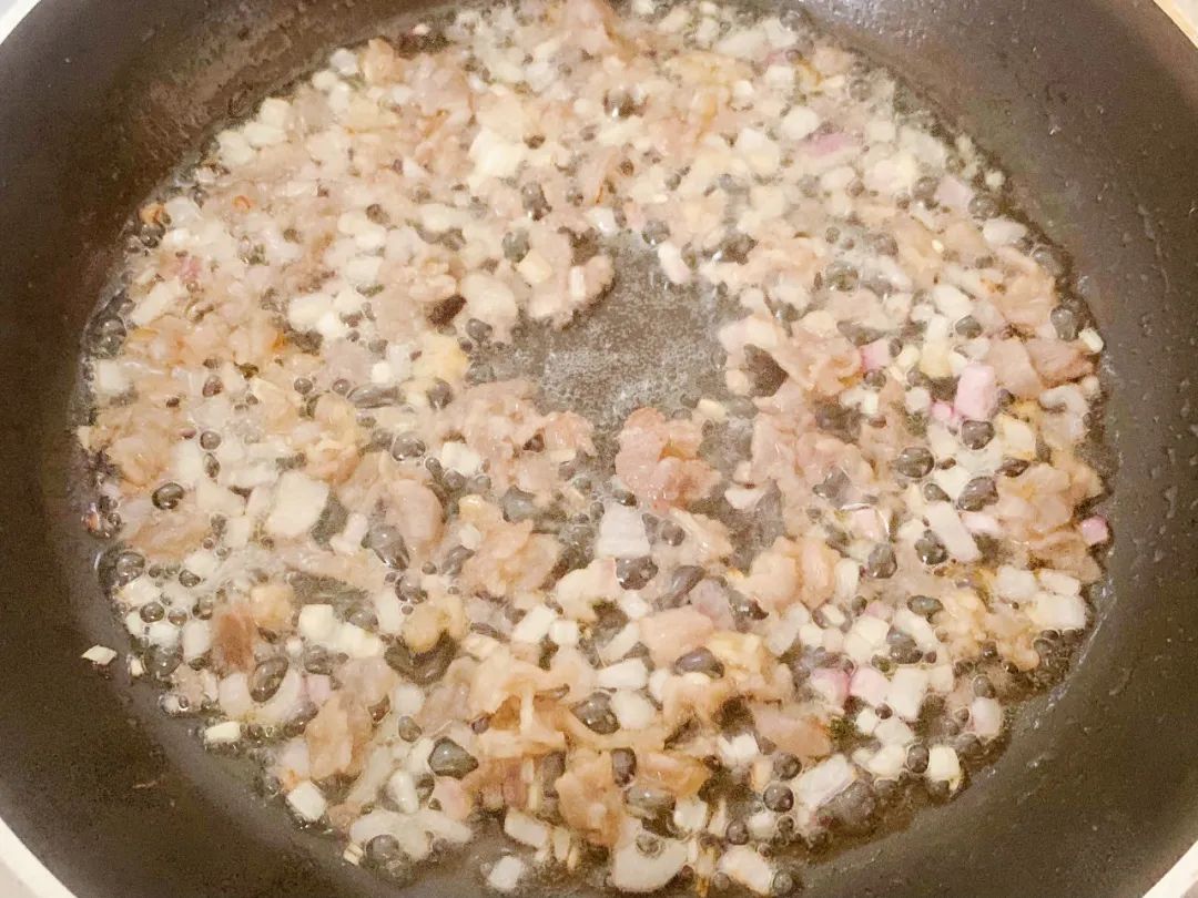洋葱碎入油锅翻炒出香味，再放入牛肉碎翻炒至变色。
