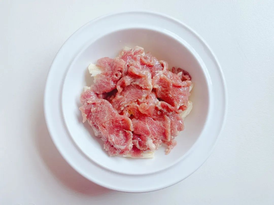 在腐竹上均匀铺上猪肉片。