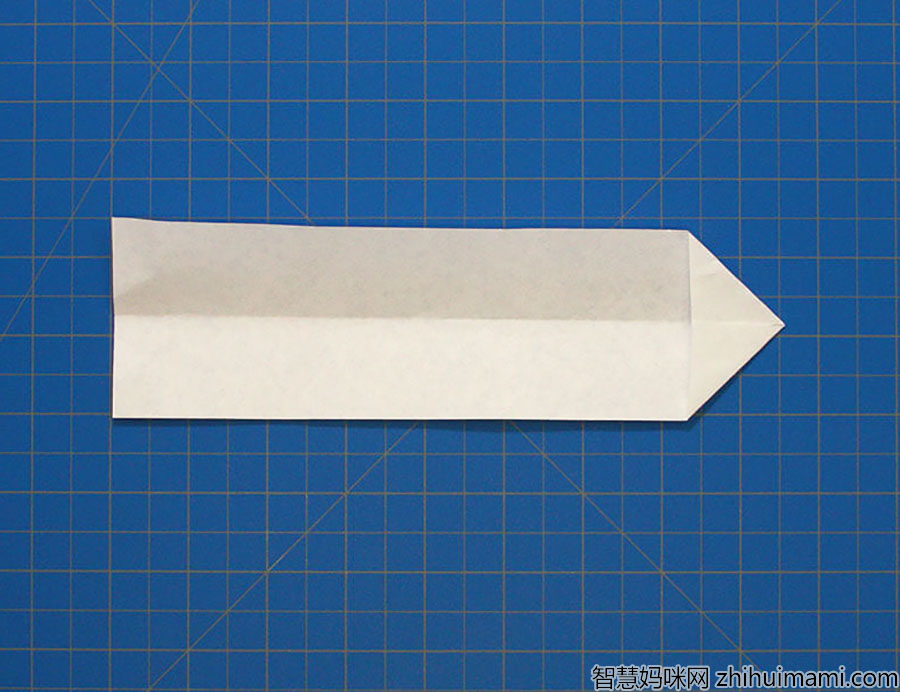 步骤5：现在，取出你之前剪下的多余部分，将顶角向中心折叠，形成一个箭头。
