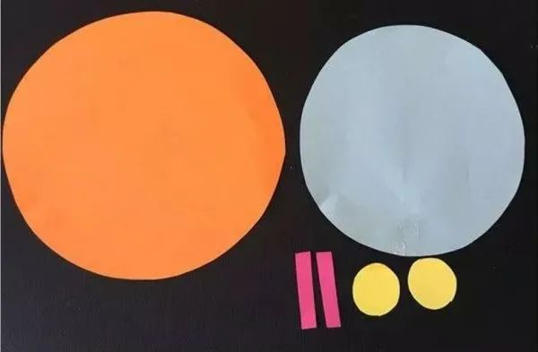 步骤1：将硬一些的卡纸剪成大圆形，白色卡纸剪成稍小一些的圆形，并剪出两个小长方条和两个小小的圆形备用。