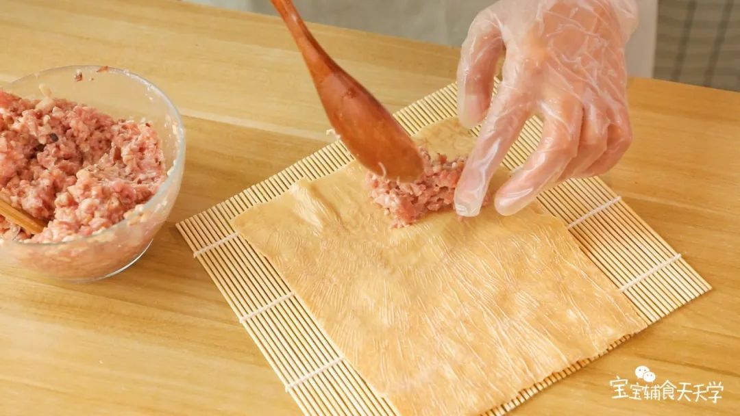 备好的肉泥，勺适量到豆腐皮上，包好