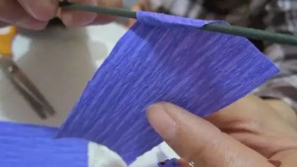 步骤2：把每片皱纹纸卷个边。