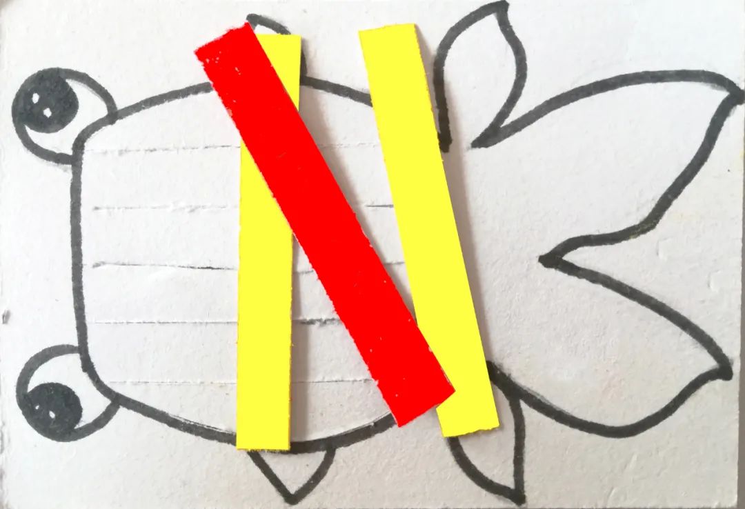 步骤4：用刻刀将金鱼的身体位置用刻刀裁开一定宽度的窄条，用剪刀将彩色纸剪成与金鱼的窄条一样的宽度。