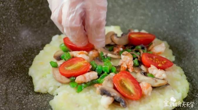 铺上炒熟的蘑菇片、青椒粒、虾肉粒，铺上小番茄