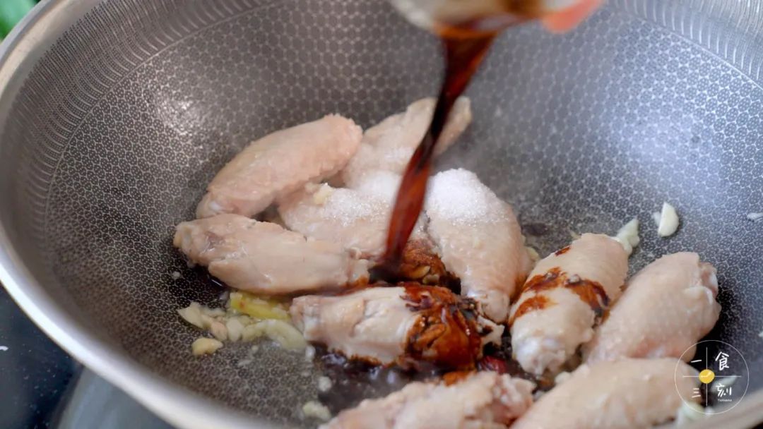 倒入生抽、老抽、糖，炒至鸡翅上色