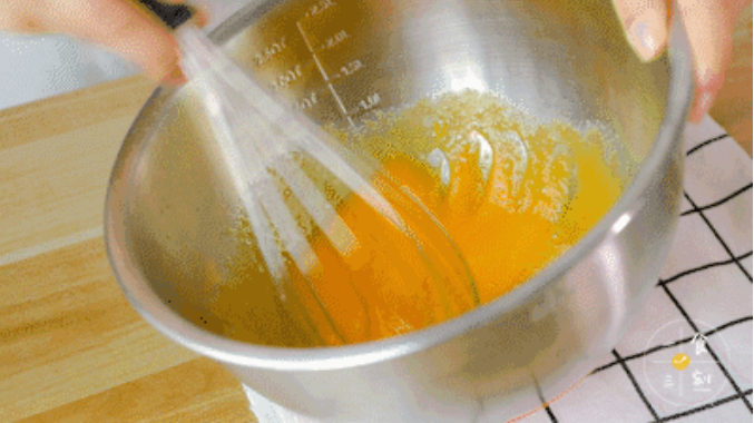 一边搅拌蛋黄一边倒入玉米油，搅拌至油完全消失