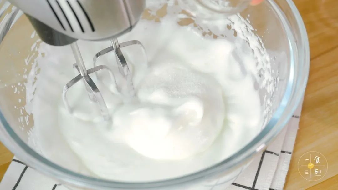 蛋白打发到开始出现纹路时，倒入剩下的砂糖