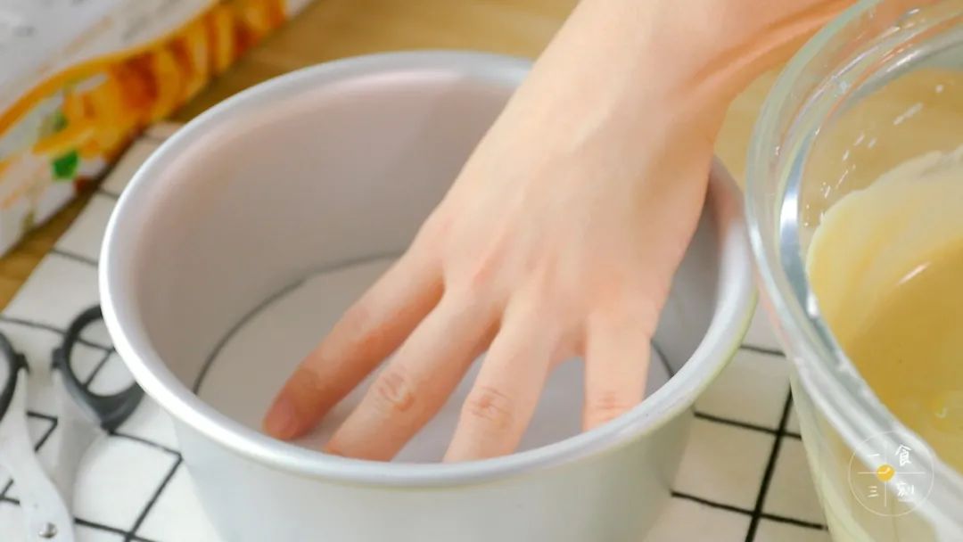 模具低底铺一张油纸，快速地倒入完成好的戚风糊