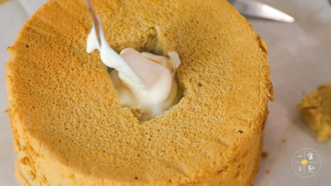 在戚风中间挖一个洞，倒入混合好的芒果肉奶油