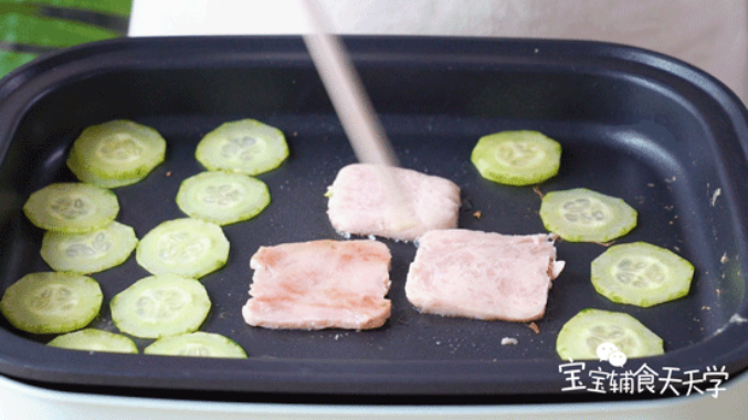 锅中放入午餐肉和黄瓜片，煎至金黄/软熟
