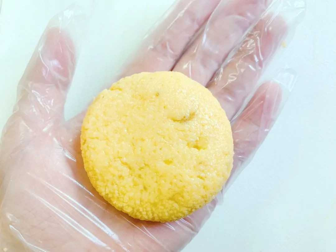 戴手套（手套上抹点油），取适量揉圆后，按压成饼状