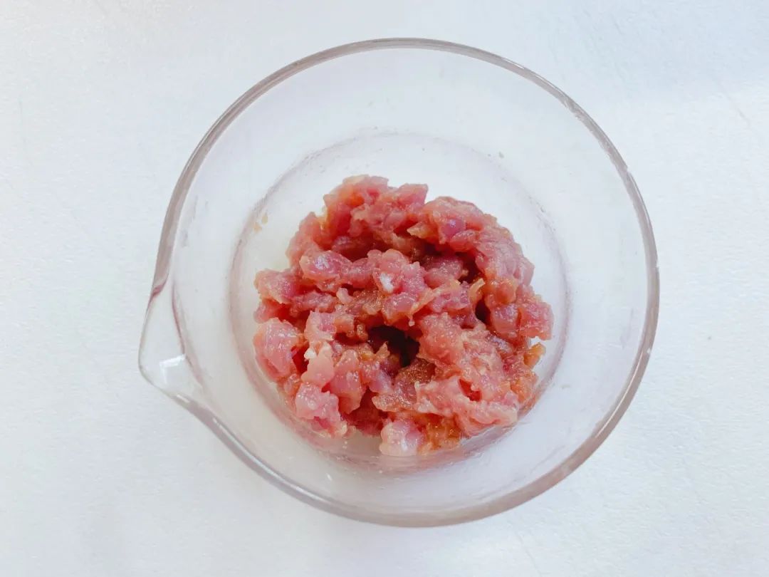 猪肉洗净剁碎，加入淀粉、1克油搅拌均匀，腌制一会儿。