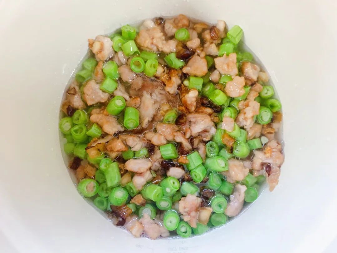 大米、燕麦片洗净，加入80毫升水，再放入炒好的菜肉。