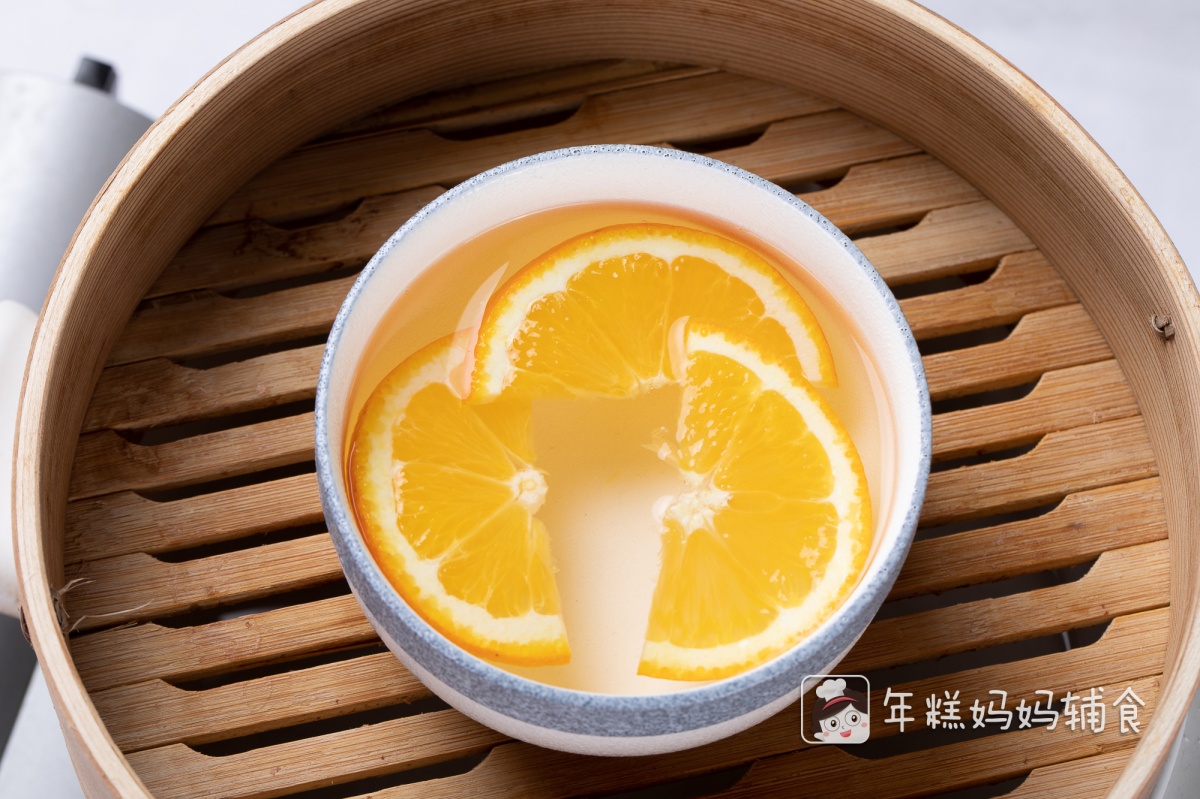 第3步：取一容器，放入适量水，加入橙子片，和少量冰糖，隔水蒸20分钟左右；（如图一碗水放了三片橙子，一颗冰糖，味道很淡，可以根据喜好自行调配橙子和冰糖的量，但给宝宝吃糖还是要限制的哦）