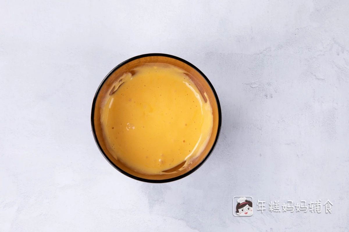蛋黄中加入15g奶粉，上下翻拌均匀；