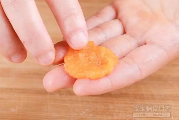 所有食材准备妥当，准备搓红薯丸啦：清洗干净手（或者戴一次性手套）取出一小撮红薯泥，用手压成饼状（如果太黏的话可先浸湿双手）；（如果红薯泥质地太稀，可以在捏丸子的过程中加一点面粉。）